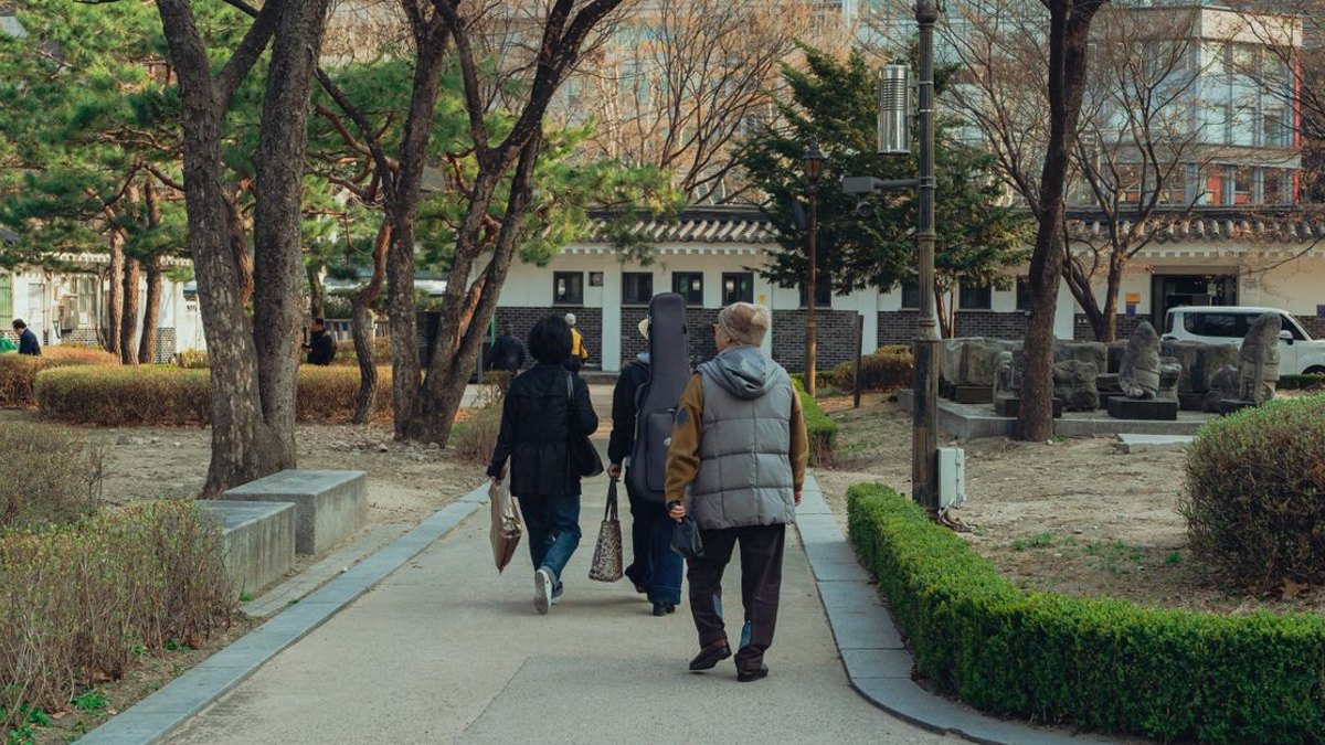 인삼꽃주 체험 외에 임직원 복지로 함께 구성할 수 있는 연계 활동은 무엇인가요? — 인삼꽃주 단독으로도 충분히 완결된 프로그램이 되지만, 반나절 하루짜리 기업 여가 프로그램으로 확장하고 싶다면 연계 활동을 함께… · 사진: People walking in a serene park in Seoul, showcasing t…